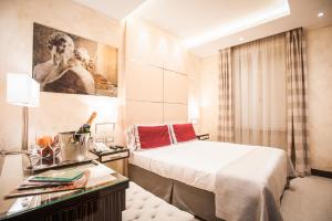 una camera d'albergo con letto e scrivania con sidro di separazione. di Maison Candia Luxury House a Roma