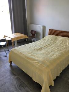 1 dormitorio con 1 cama, mesa y sillas en Oikos Olympos, en Ágios Spyrídon