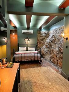 ein Schlafzimmer mit einem Bett und einer Steinwand in der Unterkunft Sunset Hotel Marmaris in Marmaris