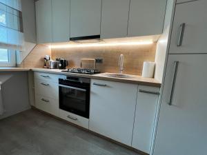 a kitchen with white cabinets and a sink at Vanilės home in Šiauliai