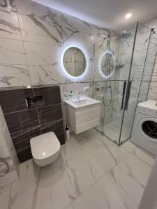 a bathroom with a toilet and a sink and a shower at Vanilės home in Šiauliai