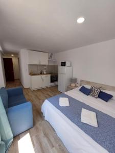 a bedroom with two beds and a couch and a kitchen at SDH apartments in Alicante
