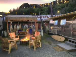 a group of chairs and a fire pit with surfboards at Cowabunga By Pacific Blue in Fort Bragg
