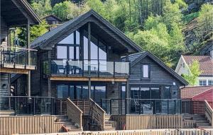 a large wooden house with a balcony and stairs at 3 Bedroom Lovely Home In Hebnes in Hebnes +13 photos