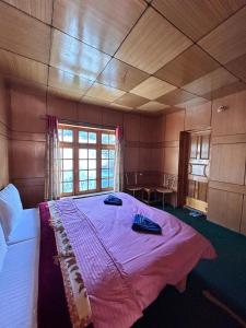 a bedroom with a large bed with a pink blanket at Zambala guest house in Leh