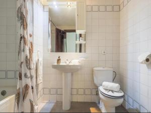 uma casa de banho com um WC, um lavatório e um espelho. em Cañailla em San Fernando