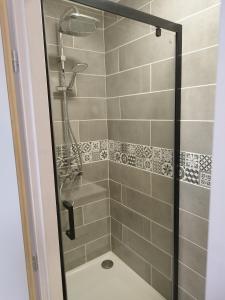 W łazience znajduje się prysznic ze szklanymi drzwiami. w obiekcie La Maison de Raph w mieście Villeneuve dʼOlmes