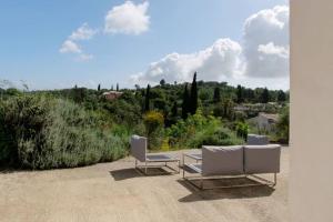 two white chairs and a table on a patio at Poulades Villa, Corfu in Danilia