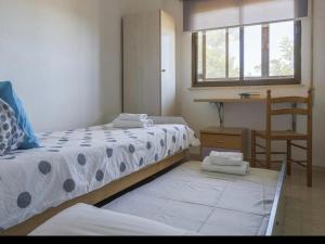 a bedroom with two beds and a window and a chair at Cañailla in San Fernando
