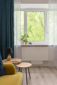 ein Wohnzimmer mit einem gelben Sofa und einem Fenster in der Unterkunft Kalevi City Center Apartment in Tartu