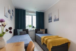 1 Schlafzimmer mit 2 Betten, einem Tisch und einem Fenster in der Unterkunft Kalevi City Center Apartment in Tartu