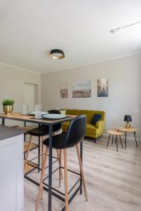 ein Wohnzimmer mit einem Tisch und einem gelben Sofa in der Unterkunft Kalevi City Center Apartment in Tartu