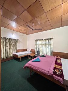 - une chambre avec un lit et un banc dans l'établissement Zambala guest house, à Leh