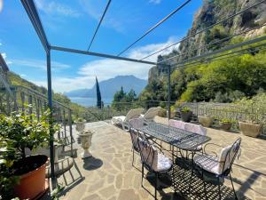 a patio with a table and chairs and mountains at ViewLake Apartment in Nago-Torbole