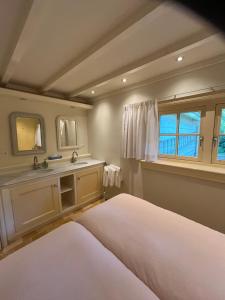 a bedroom with two beds and a sink in it at Cottage Het Beukenootje in Aerdenhout