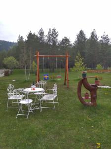 una mesa y sillas en un patio con parque infantil en Vikendica Borje, en Žabljak