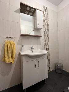 a white bathroom with a sink and a mirror at Sobe Baosici Marina in Herceg-Novi
