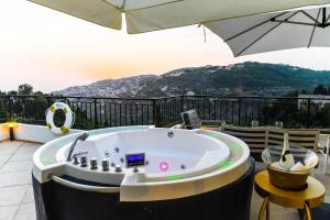 - un bain à remous sur une terrasse avec un parasol dans l'établissement Beit Lebbos Boutique Hotel, à Beiteddine