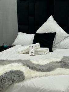 a white bed with a pile of blankets on it at Serenity Guest House in Soweto