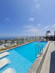 a large swimming pool with a view of the ocean at Luxury Apartment in Magdalena 2BR limit San Isidro in Lima