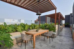 a wooden table and chairs on the roof of a building at Luxury Apartment in Magdalena 2BR limit San Isidro in Lima
