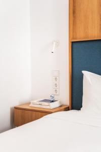 a bed with a blue headboard and a book on a night stand at Hotel Kitchen59 in Sofia