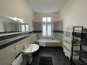a bathroom with a sink and a bath tub at LUCKY STAYS LS07 - Vollausstattung - Zentrum - Aufzug - große Küche - 2 Zimmer - Smart-TV in Magdeburg +33 photos