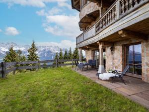 a house with a balcony with a view of mountains at jezz AlmResort Ellmau in Ellmau