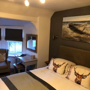 Borgie Lodge Hotel في Borgie: غرفة نوم مع سرير مع رأسيّ غزلان على الوسائد