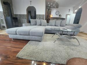 a living room with a couch and a glass table at Morrison Rezidence in Miercurea-Ciuc