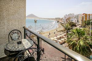 a balcony with a table and chairs and a beach at Apartments Alba in El Médano