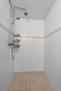 a shower in a bathroom with white tiles at Old Post Office now cosy apartment close to nature in Hedenäset