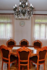 a dining room table with chairs and a chandelier at Guest House Kvariati in Kvariati