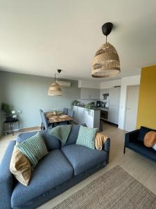 Il comprend un salon avec un canapé bleu et une cuisine. dans l'établissement Estrella del Mar III, à Ostende