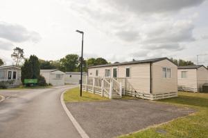a row of mobile homes on the side of a road at Luxury holiday retreat set within Oakdene Forest - Park activities pass included free! in Saint Leonards