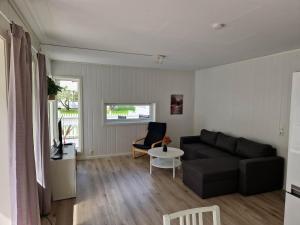 莱达尔绥里Hillegård的客厅里有一张黑色沙发和一张桌子