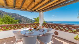 stół na balkonie z widokiem na ocean w obiekcie Villa Azul de Frigiliana by Ruralidays w mieście Frigiliana