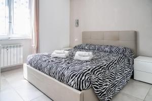 1 cama con estampado de cebra en un dormitorio blanco en Selly House Allesandria, en Alessandria