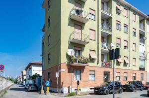 un edificio alto con coches estacionados frente a él en Selly House Allesandria, en Alessandria