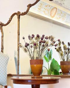 due vasi su un tavolo con dei fiori di Biagetti Bedrooms Affittacamere a Santa Maria degli Angeli