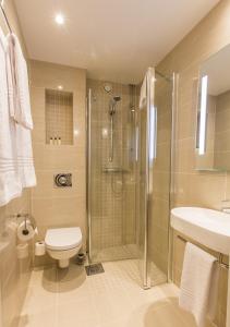 a bathroom with a shower and a toilet and a sink at Saga Apartments Oslo in Oslo