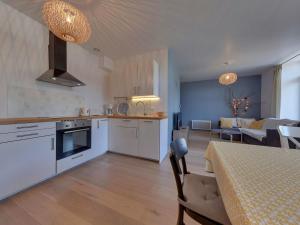 eine Küche und ein Wohnzimmer mit Tisch und ein Esszimmer in der Unterkunft La Bourboule Centre - Magnifique T3 avec Balcon, Wi-Fi, Animaux Acceptés - FR-1-608-119 in La Bourboule