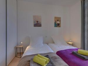 zwei Betten nebeneinander in einem Zimmer in der Unterkunft La Bourboule Centre - Magnifique T3 avec Balcon, Wi-Fi, Animaux Acceptés - FR-1-608-119 in La Bourboule