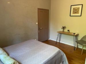 1 dormitorio con cama, mesa y escritorio en Villa LEONA, en Bollène