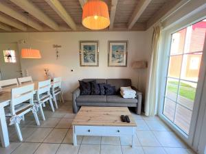 ein Wohnzimmer mit einem Sofa und einem Tisch in der Unterkunft Strandpark Sierksdorf H054 in Sierksdorf