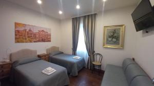 a hotel room with two beds and a couch at L'Oasi al Pigneto - Guest house in Rome