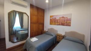 a room with two beds and a mirror at L'Oasi al Pigneto - Guest house in Rome