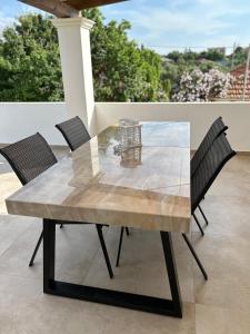 een glazen tafel met stoelen op een patio bij Kouzoulis House in Éxo Khóra