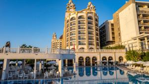 un hôtel avec une piscine en face des bâtiments dans l'établissement J'adore Deluxe Hotel & Spa Ultra All Inclusive, à Sidé