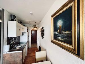 una cocina con una pintura en la pared en Appartement du marin art & océan, en Saint-Jean-de-Monts